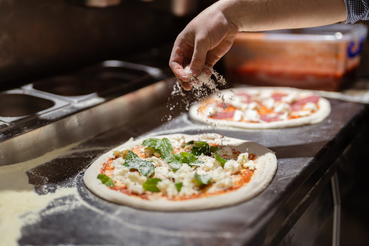 making pizzas with spicy hot pepper mix