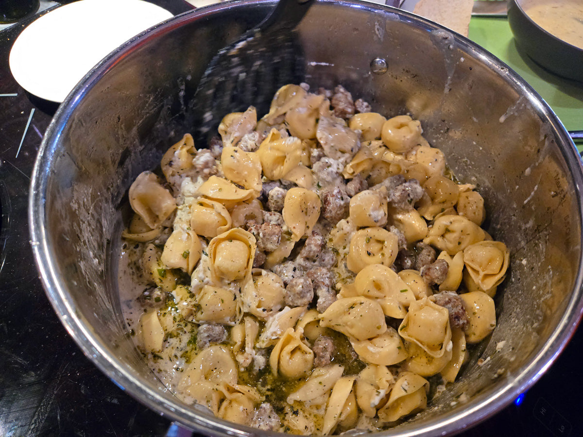 mixing in hot pepper spice with pasta dish
